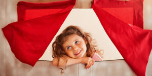 Girl behind homemade puppet show curtain