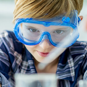 Boy wearing safety glasses using a dropper