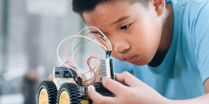Concentrated boy creating robot at lab.