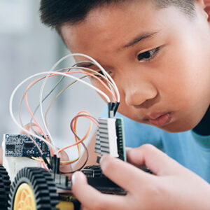 Concentrated boy creating robot at lab.