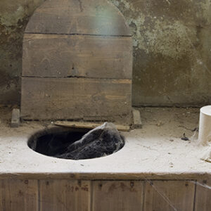 Outhouse toilet with wooden seat and lid open