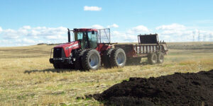 Tractor in Eastern Washington applying biosolids to field growing feed crops