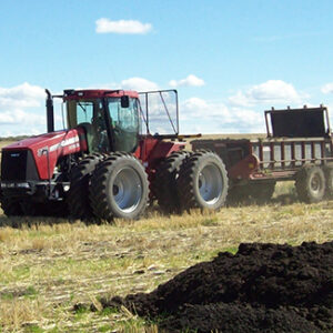Tractor in Eastern Washington applying biosolids to field growing feed crops