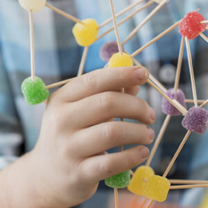 Boy creates something from toothpicks and gum drop candy